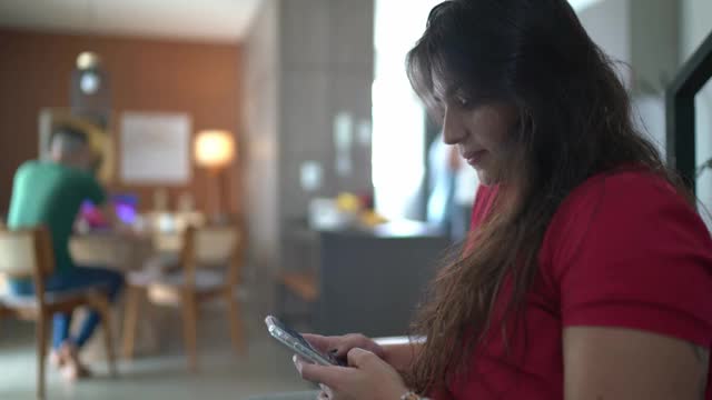 一个在家里使用智能手机的女人的肖像视频素材
