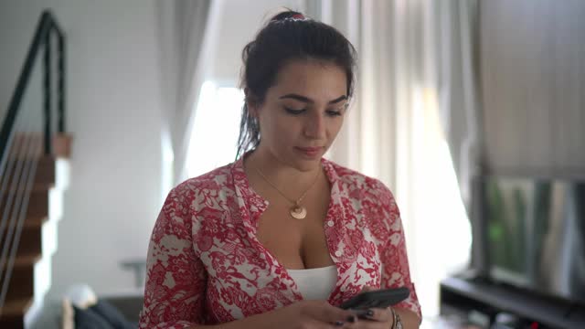 一个在家里使用智能手机的女人的肖像视频下载