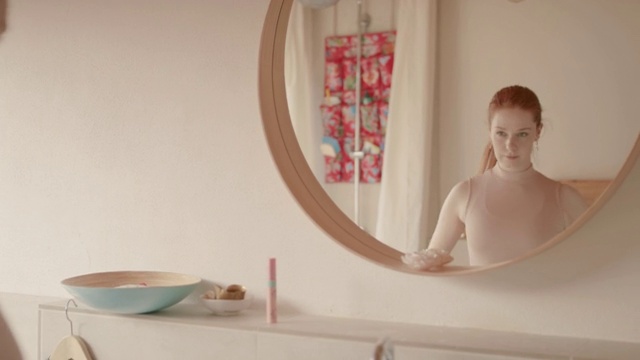 一名年轻女子早晨在浴室镜子前梳妆视频下载