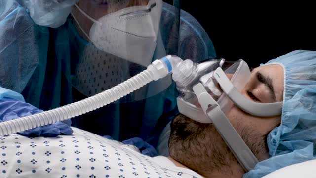 连接呼吸机的年轻男子正在接受医护人员的检查视频素材