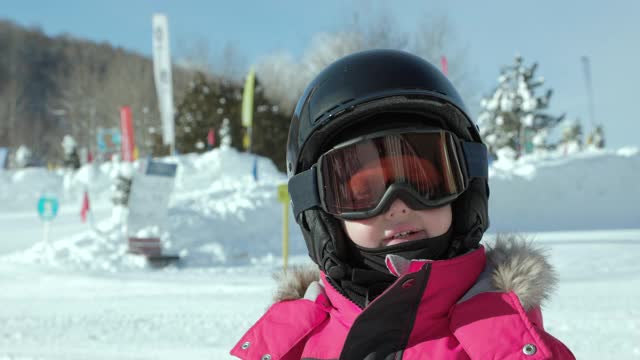 小男孩戴着滑雪头盔和滑雪镜在滑雪胜地的特写视频素材