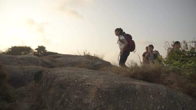 徒步旅行和露营概念。剪影视频，一群四男四女徒步和登山的人在晚上徒步旅行。视频素材