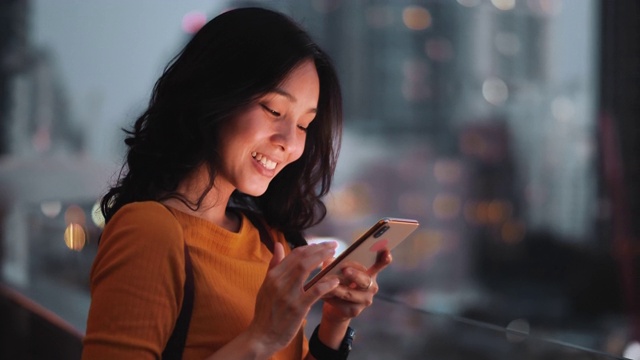 亚洲女人在夜城使用智能手机视频素材