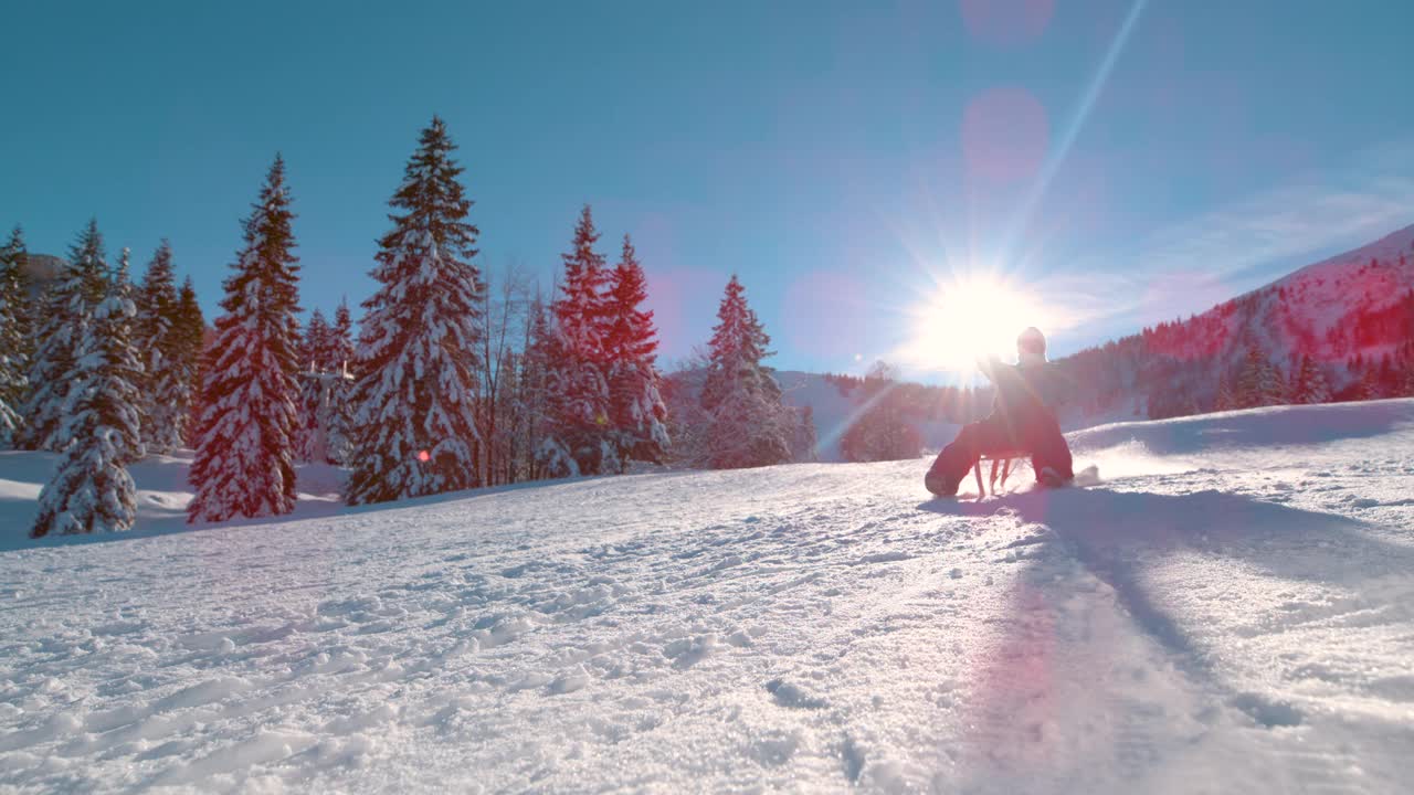 低角度:在Kranjska Gora度假的快乐女人拉着雪橇从雪山上滑下来。视频素材