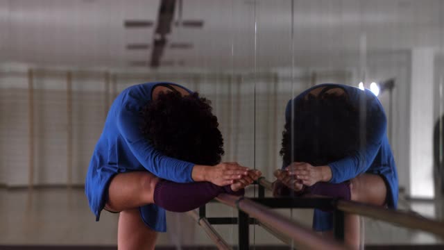 非裔美国舞蹈家伸展手臂和腿在工作室的杠铃视频素材