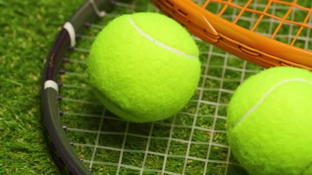 网球和球拍在绿色草地的背景近距离视频下载