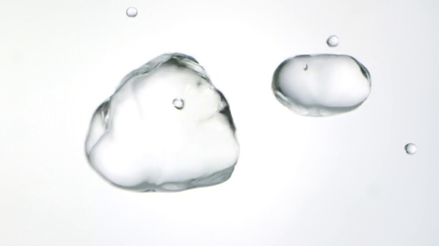 近距离微距和超级慢动作的浮动清澈的水滴对白色的背景视频购买
