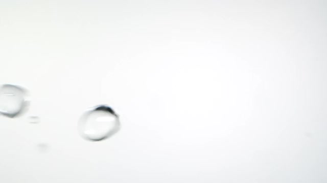 近距离微距和超级慢动作的浮动清澈的水滴对白色的背景视频素材