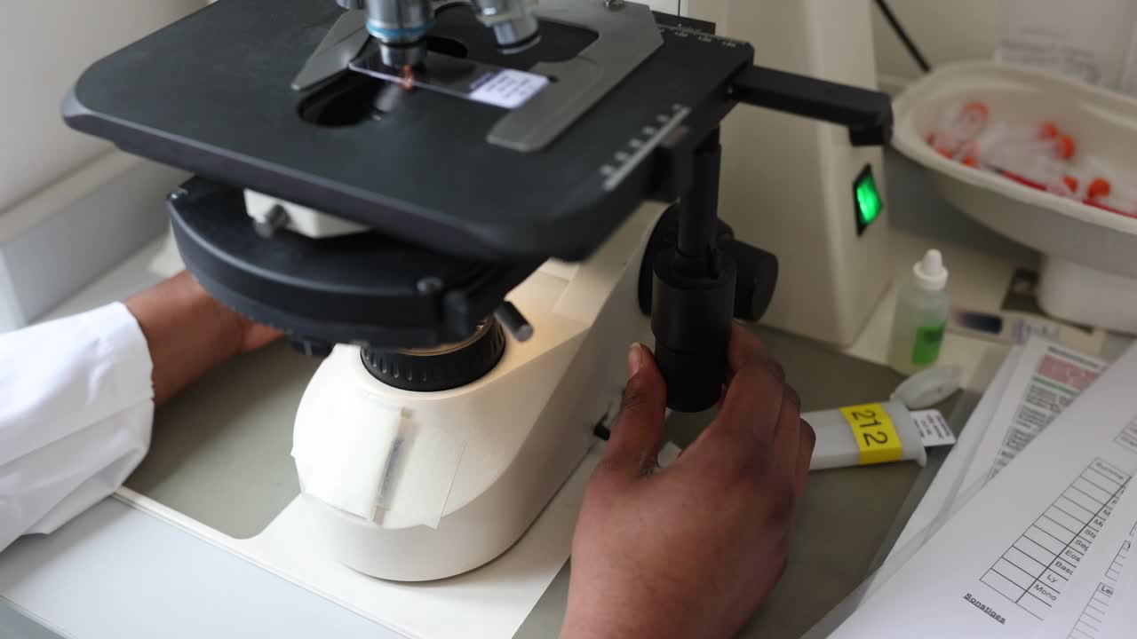 在实验室使用显微镜的微生物学家的特写。视频下载
