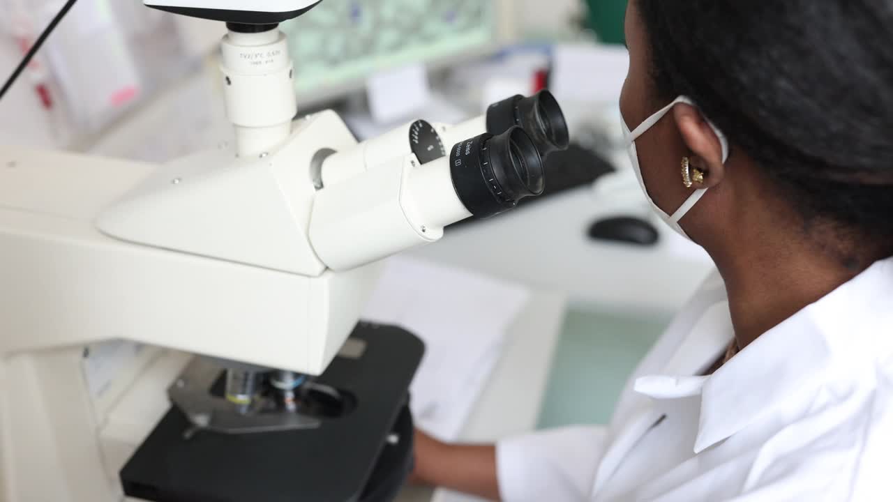 在实验室里使用显微镜的女性微生物学家视频素材