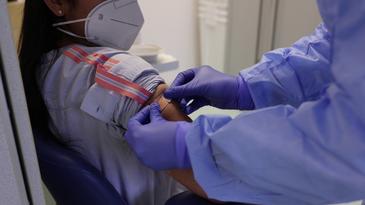 医务人员在接种完新冠肺炎疫苗后包扎绷带视频下载