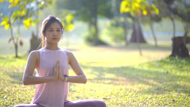 日落时分，美丽的女人在公园里练习瑜伽视频下载