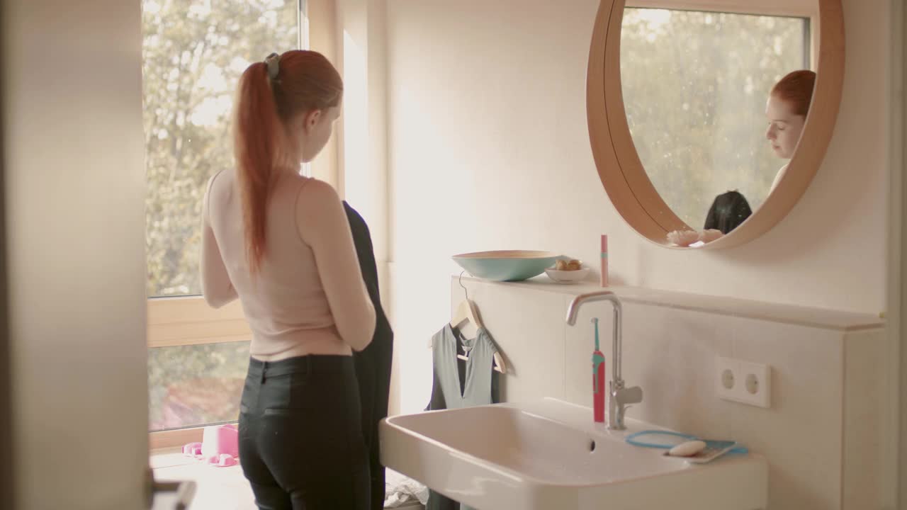 年轻女子在镜子前穿西装视频素材