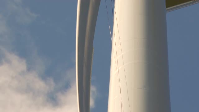 近距离观察从底部的风力涡轮机和两个绳索访问技术人员-工业攀岩者绳索上的叶片，做检查，晴朗的天空和阳光明媚的一天。塔。视频素材