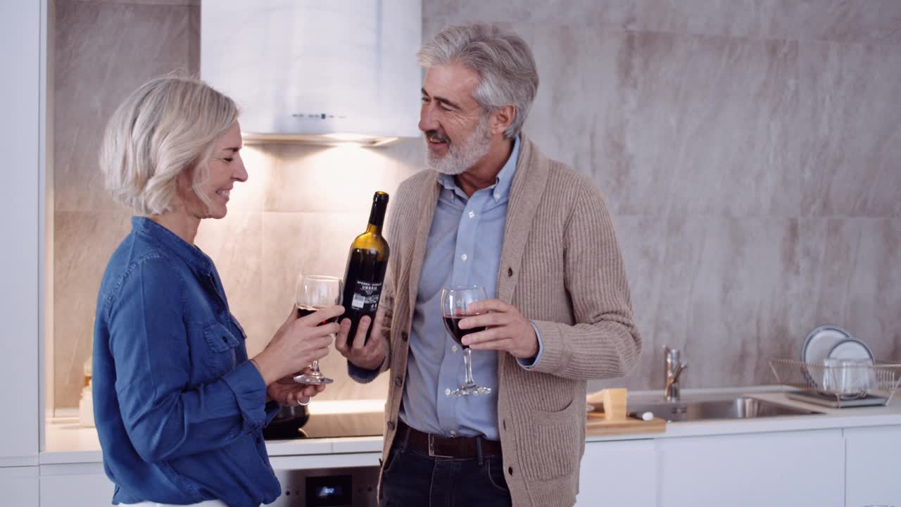 一对成年夫妇在家厨房喝红酒的慢镜头视频素材