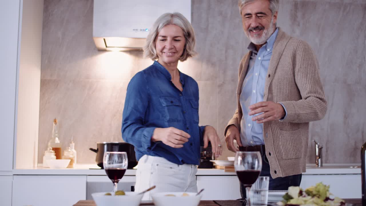 一对成年夫妇在家厨房喝红酒的慢镜头视频素材
