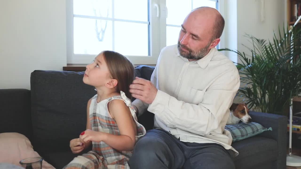 父亲在家为女儿梳头视频素材