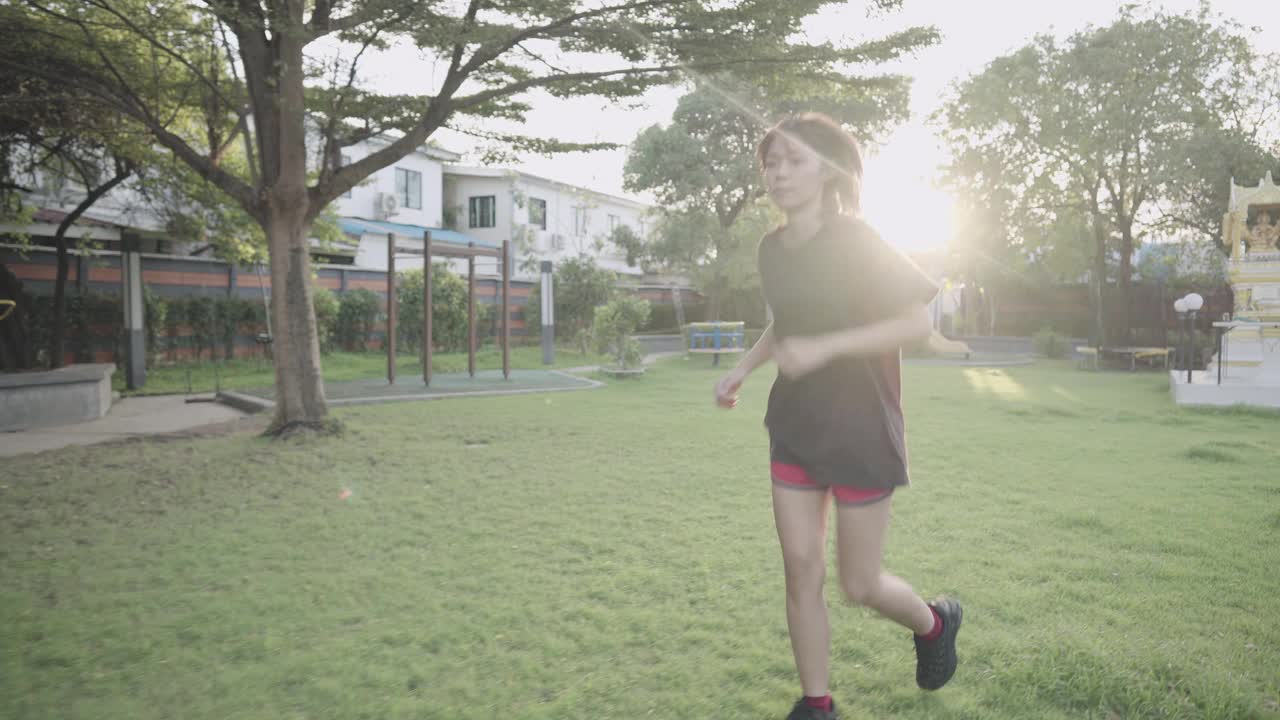 年轻的东南亚女性在公园里跑步，在禁闭期间保持健康，有氧运动燃烧脂肪，日落黄金小时阳光泄漏，自律投入工作，4k视频素材