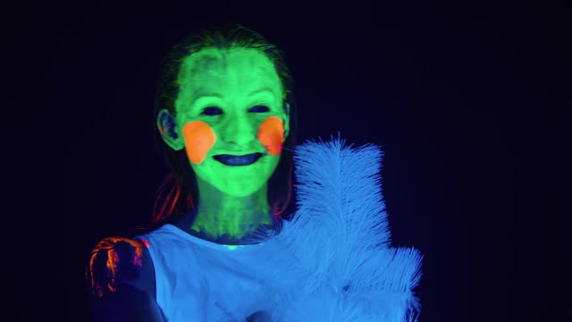 彩脸跳舞的女人和紫外线下的圣诞树视频下载