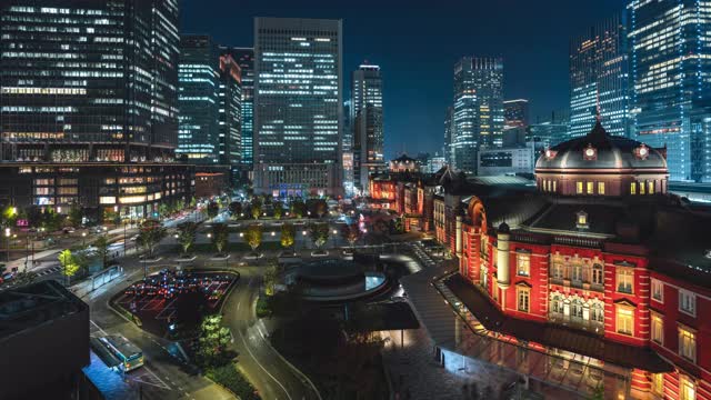 4K延时:倾斜夜间场景的行人旅游人群步行和汽车交通在东京车站市中心附近的火车站，高峰时间视频下载