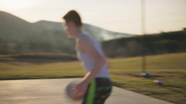 活跃的男孩运球和玩篮球，并成功地投篮视频素材