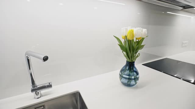 镜头对准干净的柜台，时髦的厨房里有一束新鲜的郁金香。广角镜头视频下载