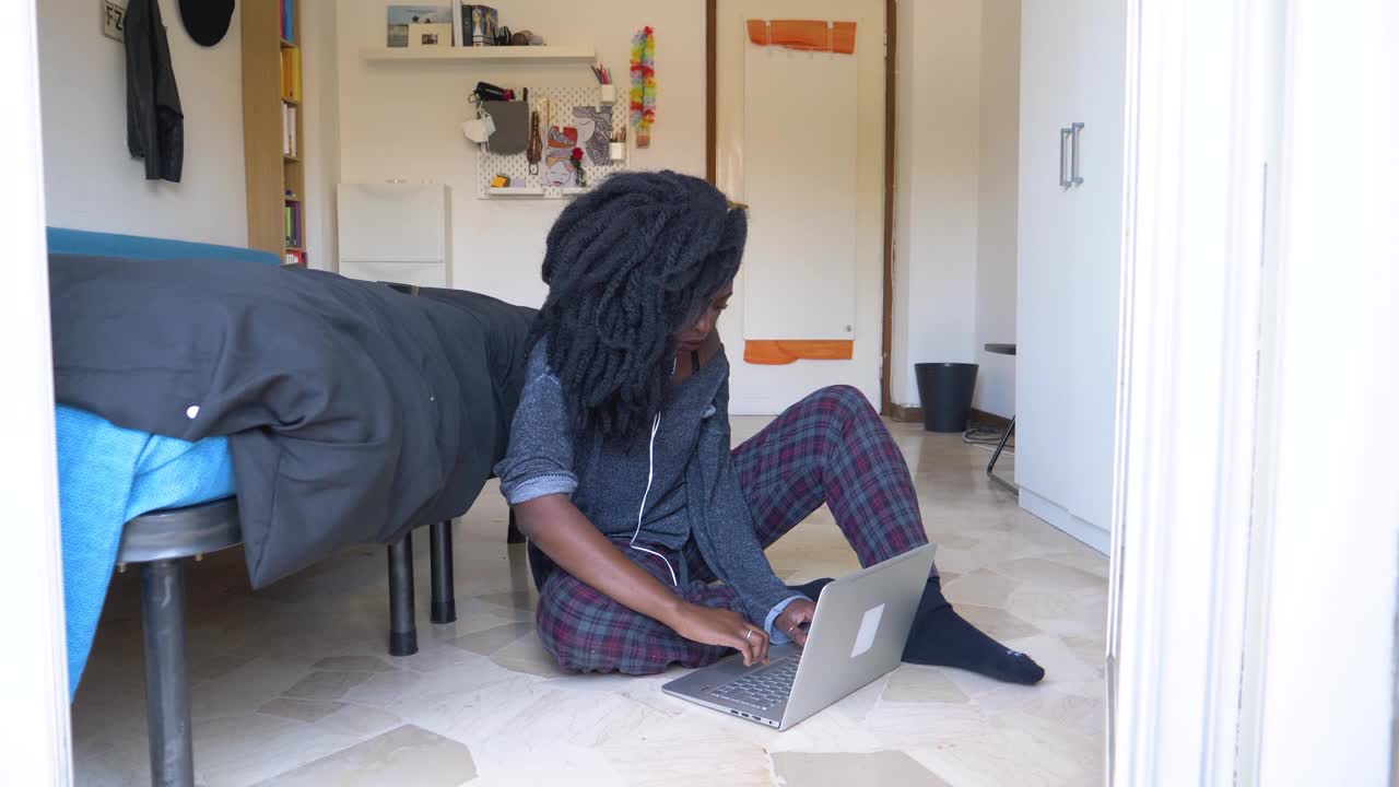 年轻女子坐在地板上用笔记本电脑视频素材