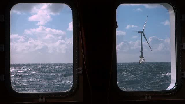 从移动的帆船上看离岸风力涡轮机真窗。8MW风力发电机，82米叶片。天气晴朗，天空壮观。视频素材