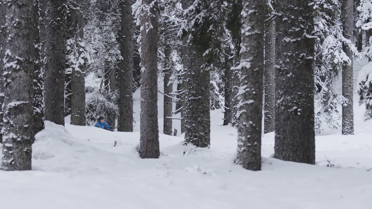 职业运动员的慢动作镜头，越野滑雪运动员在冰雪覆盖的冰冻森林中滑行视频素材
