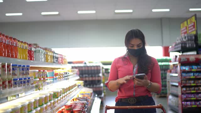 年轻女子戴着口罩在超市购买requeijão视频素材