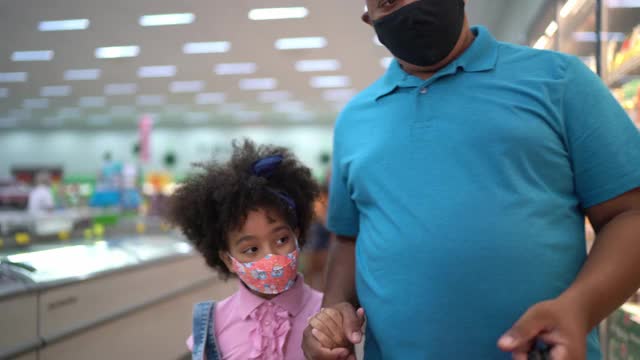 爸爸和女儿在超市买冷冻食品——戴着口罩视频下载