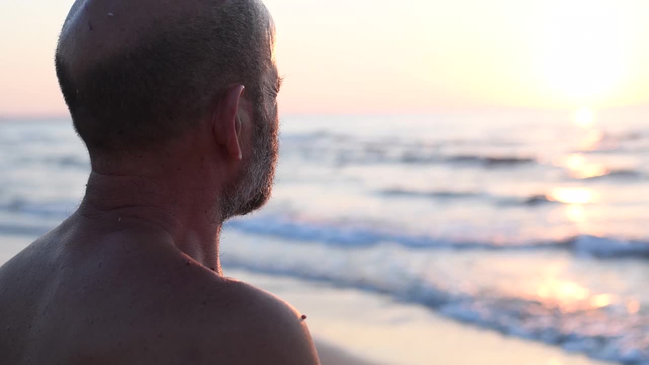 后视图的老年人享受日落在海滩视频下载