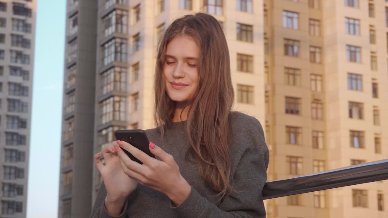 年轻女子在城市的社交网络上使用短信视频素材
