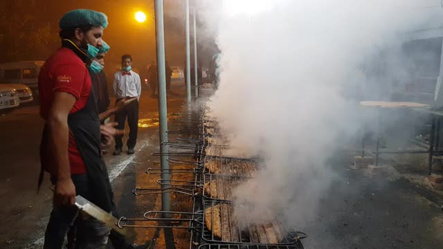 2019冠状病毒病大流行期间，戴口罩的厨师正在准备烧烤鱼。视频下载