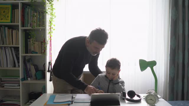 父亲帮助儿子做作业。视频素材