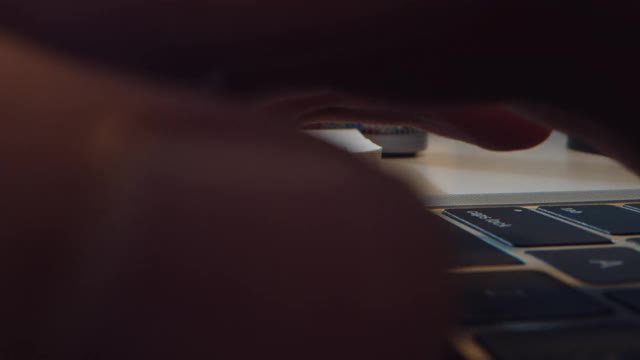 近距离的手年轻的亚洲妇女打字笔记本电脑，而从家庭办公室在晚上工作。视频下载