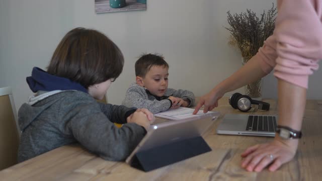 母亲在家亲手帮儿子做家庭作业。视频素材