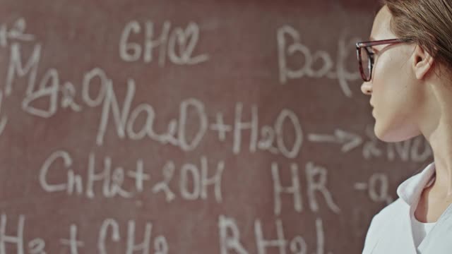 年轻的科学家教授在实验室的黑板上写化学公式视频下载