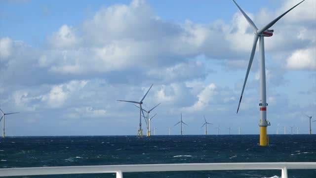 对大型海上风力涡轮机的看法-在北海风电场。从中转船(船、轮渡)甲板看真栏杆，海上航行真风电场。视频素材