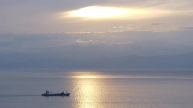 一艘船经过阳光反射在海上在日落视频下载