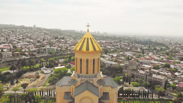 空中近距离观看圣三一大教堂的金色圆顶。格鲁吉亚东正教教堂视频下载