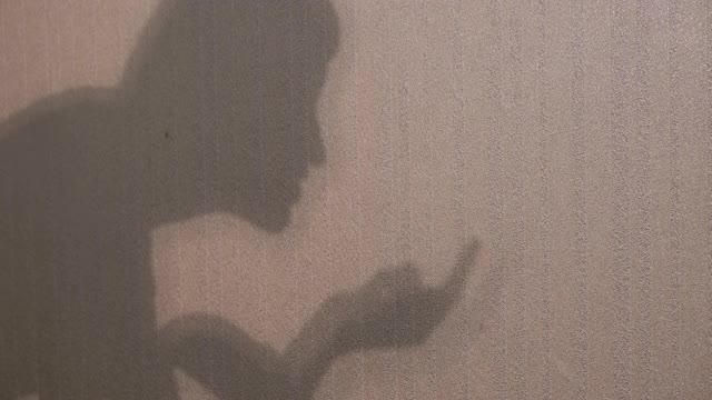 不认识的女人展示了一个剧院的影子在墙上视频下载
