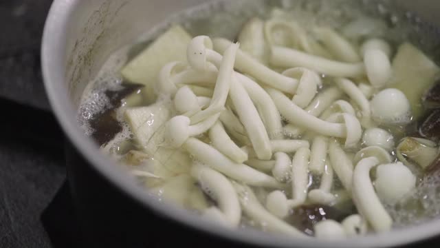 SLO MO:特写的白色Shimeji蘑菇煮在滚烫的汤。视频下载
