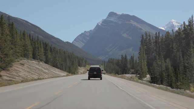 在不列颠哥伦比亚省的93号高速公路的峡谷路线上，壮丽的风景，岩石山脉，冰川在阳光明媚的日子里蓝色和绿色的国家公园视频下载
