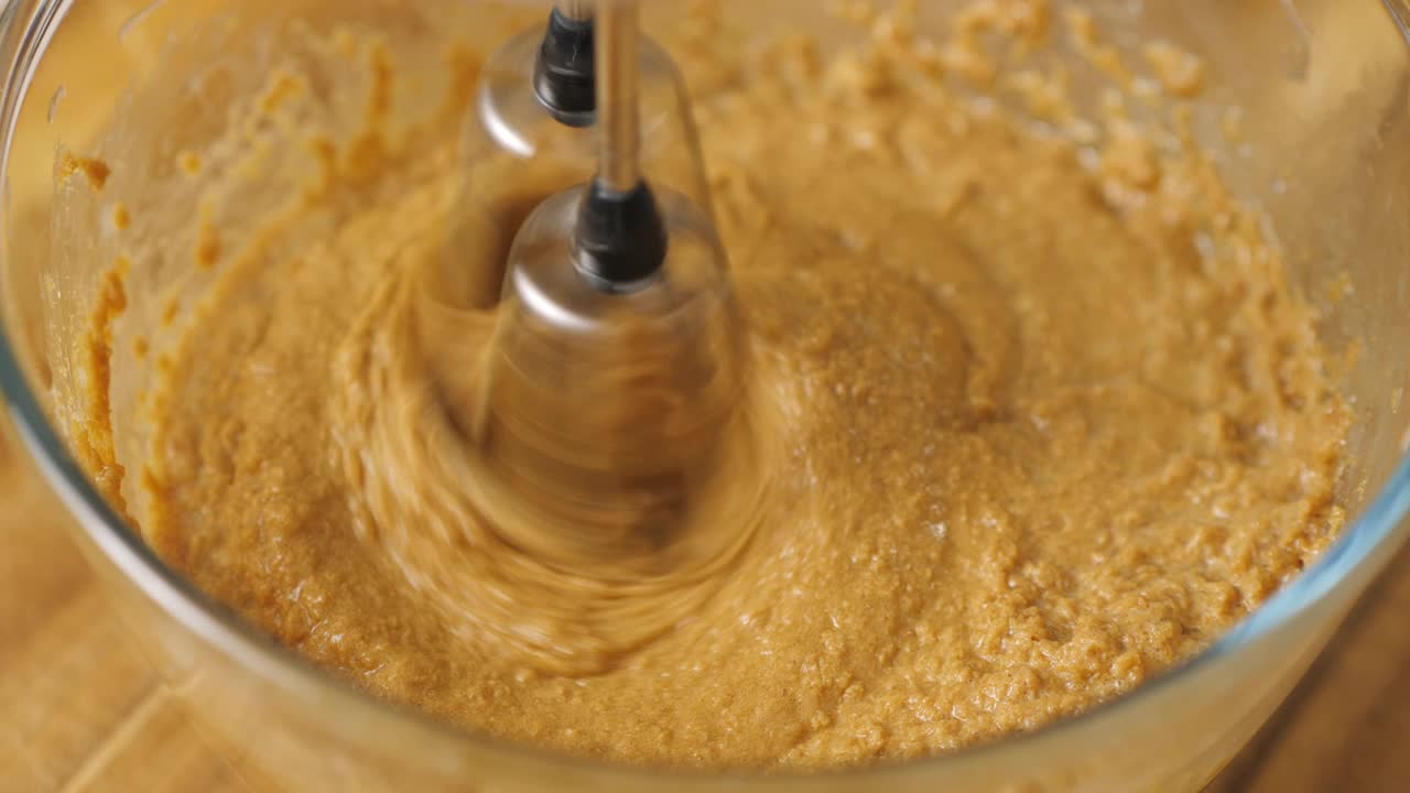 用手动电动搅拌器将鸡蛋、牛油、砂糖搅拌在一起，制作水果蛋糕视频素材