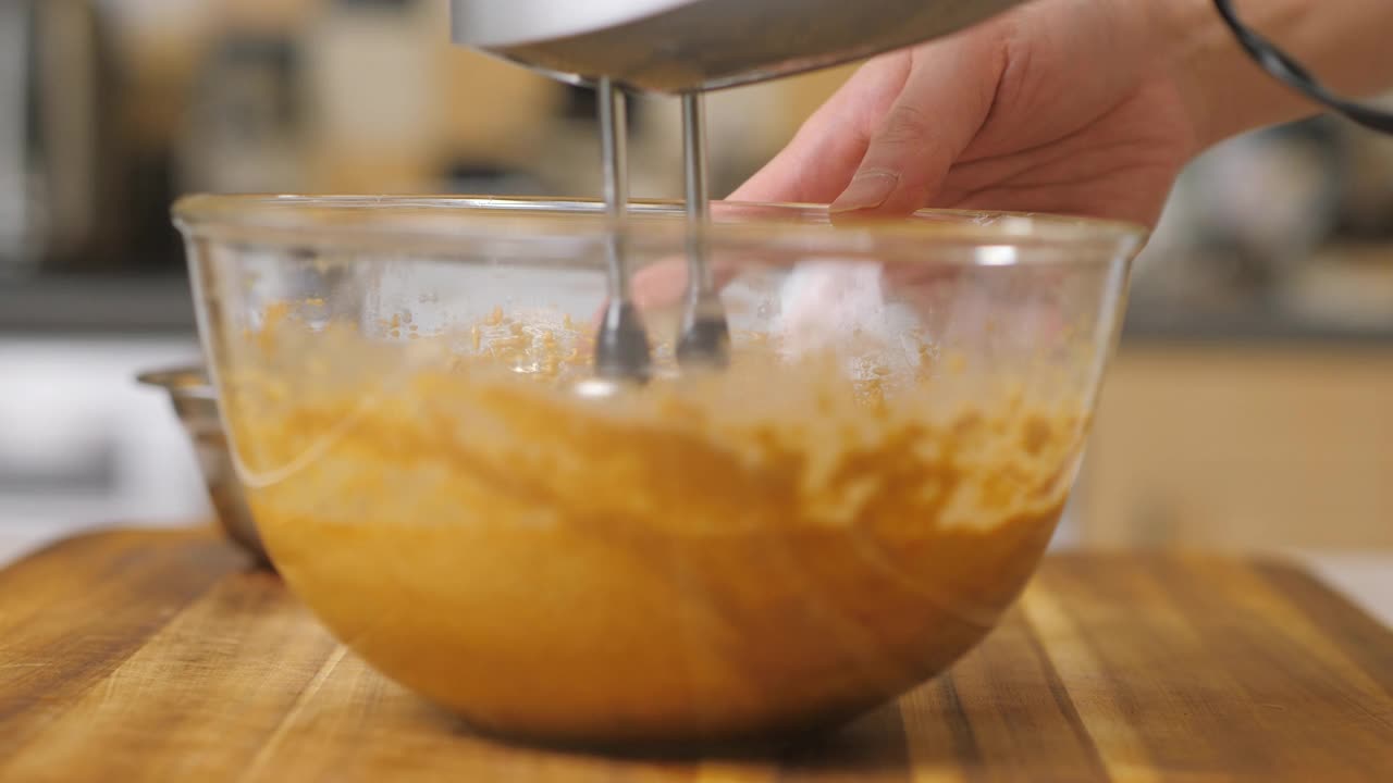用手动电动搅拌器将鸡蛋、牛油、砂糖搅拌在一起，制作水果蛋糕视频素材