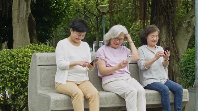 中国银发冲浪者在户外玩智能手机视频素材