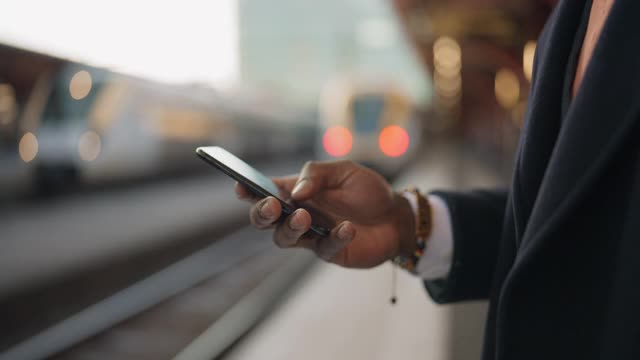 一个在火车站用智能手机的商人视频素材
