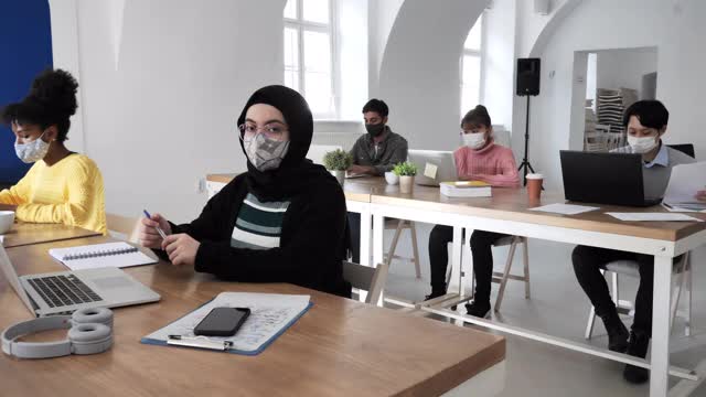 冠状病毒感染期间在办公室工作的中东妇女戴着头巾视频素材