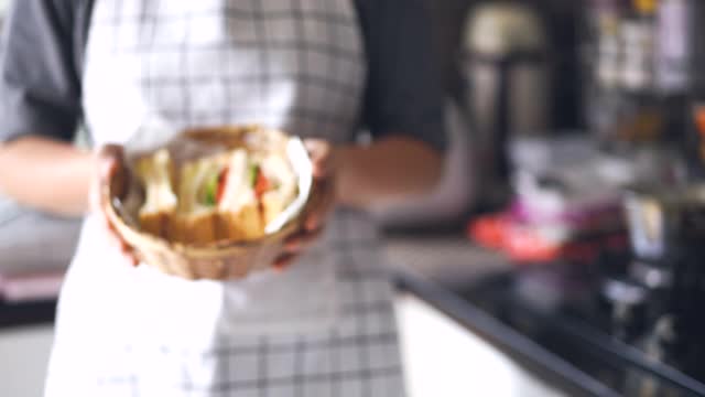 女厨师端上一个三明治，在前面展示视频素材